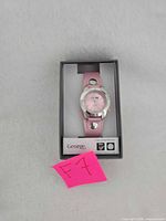 Watch in box front view showing dial and strap