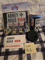 All three items: sealed mouse pad, travel mug with lid, postcard