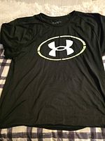 Front view of black Under Armour T-shirt showing logo, fabric texture and overall condition