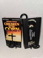 Front view of VHS sleeve beside tape showing label and artwork