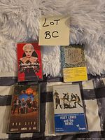 Front view of four cassette tapes and cases: Madonna, Night Ranger Big Life, Three Dog Night, Huey Lewis and the News