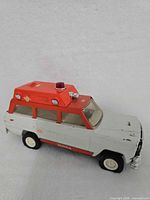 Passenger-side view of toy ambulance showing body, roof module, wheels
