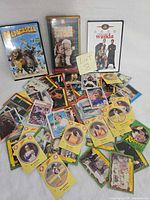 Overall lot showing three video cases and spread of trading cards