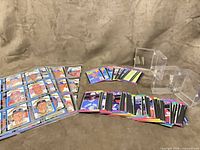 Binder page with nine-pocket sleeve containing baseball cards, two stacks of loose cards, four clear plastic card holders