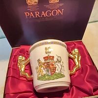 Mug in presentation box showing crest side, gilt handles, satin lining