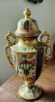 Full view of urn showing shape, lid, handles, decoration