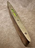 Oblique view showing brass top plate, horizontal vial window, engraved maker’s mark