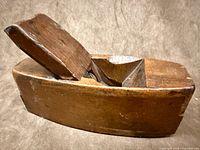 Left side view of wooden coffin plane showing wedge and iron