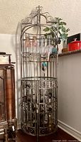 Full view of wrought iron birdcage wine rack cabinet showing overall design and height
