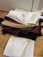 Stack of assorted lining fabrics with note reading 'Lining Cloth'
