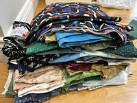 Stacked pile of assorted cotton fabric pieces showing varied prints and colors