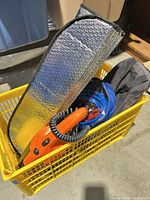 Overall lot in yellow crate showing inflator, sunshade, bags