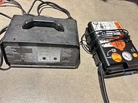 Battery charger and tire inflator side by side showing overall condition and included cords