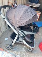 Left side view of stroller showing canopy, tray, wheels