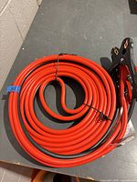 Coiled red and black jumper cables showing overall length and insulation