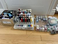 Overview of thread spools on racks, metal tin, storage boxes, notions bag