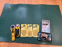 All items laid out: two rotary cutters, three blade packs, Dexter mat cutter with box