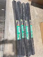 four packaged black edging strips on floor