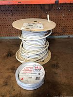 Spool of white jacketed cable and sealed 14/2 coil together