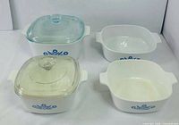 Four Corning Ware casseroles showing two with lids and two without