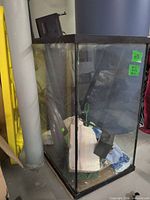 Full view of glass aquarium with accessories inside and hood on top