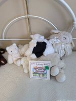 Group of stuffed animals and book on bed