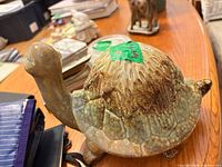 Side view of glazed ceramic turtle figurine on table