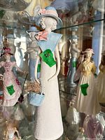 Full front view of pastel ceramic figurine in display case