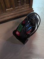 Side view of Dirt Devil handheld vacuum showing body, handle, and cord