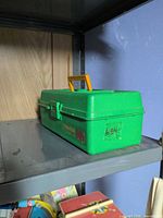 closed green Fisherkid tackle box on shelf