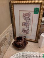 Framed teddy bear print beside ceramic pitcher and basin