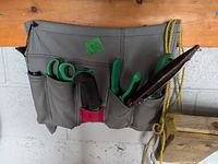 Front view of grey pouch holding garden tools