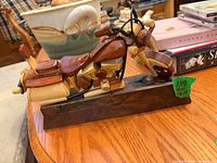 full view of handcrafted wooden motorcycle on base