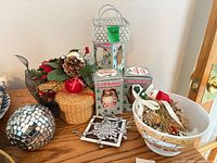 Wide view of assorted holiday decorations including L'il Chimer boxes, wicker baskets, Ricardo bowl, disco ball, silver frames, pine cone arrangement