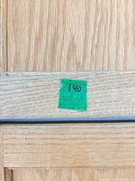 green tape 140 on wood surface