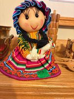 Front view of Peruvian cloth doll displaying colourful attire and facial features