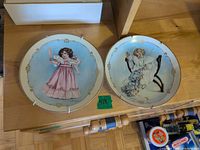 Both Little Ladies plates showing illustrations, gold trim and metal hangers