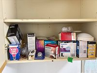 Shelf containing boxed and loose light bulbs of mixed brands and types