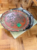 Red and gold decorative tray resting on stainless steel divided tray