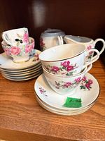 Group view of teacups, saucers, creamer and lidded sugar bowl