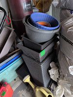 Stacked planters, trays and watering can showing variety and condition