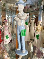 Front view of porcelain male figurine with blue hat, suspenders and trousers