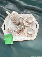Full view of porcelain miniature tea set on tray showing all pieces and Hummel design