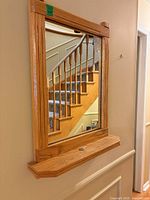 Front view of oak framed rectangular wall mirror mounted on wall