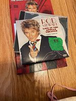 Front view showing Rod Stewart Live at the Apollo Theater DVD sleeve on top of booklet and CDs