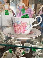 Teacup on saucer showing floral design and gilt trim