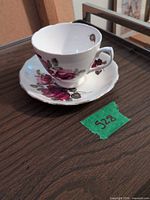 Royal Vale bone china teacup and saucer with rose pattern, showing overall design and wear