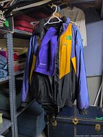 Jacket and pants hanging on rack showing front color pattern and size