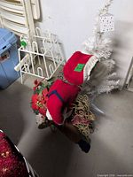 Overhead view of doll, poinsettia arrangement, white tree and reindeer