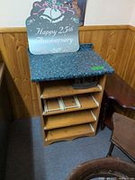 Front view of pine cabinet showing blue laminate top and four pull-out shelves